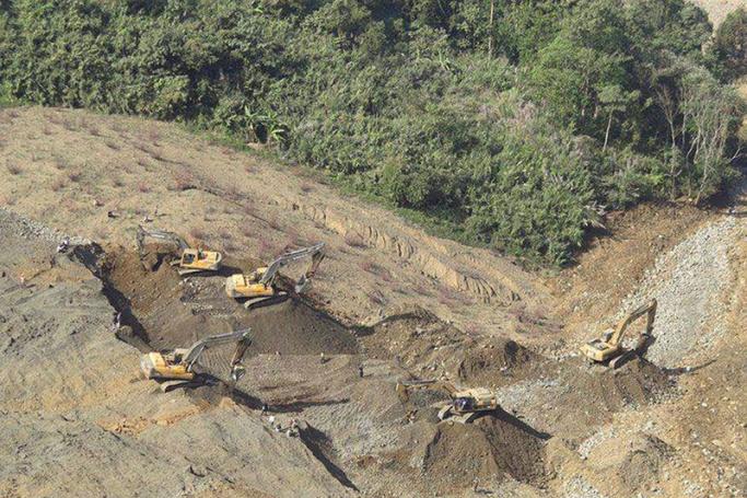 A general view shows Myanmar rescue workers with backhoes search for miners after a landslide at Hpa Kant jade mining area, Kachin State, northern Myanmar, 26 December 2015. Photo: EPA