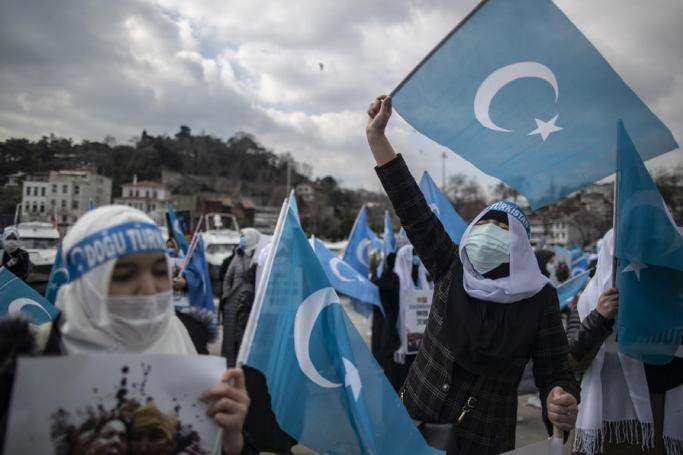 Uyghur women wearing face masks hold placards and East Turkestan flags during a protest against China on the occasion of the International Women's Day near the Chinese Consulate in Istanbul, Turkey, 08 March 2021.  Photo: EPA