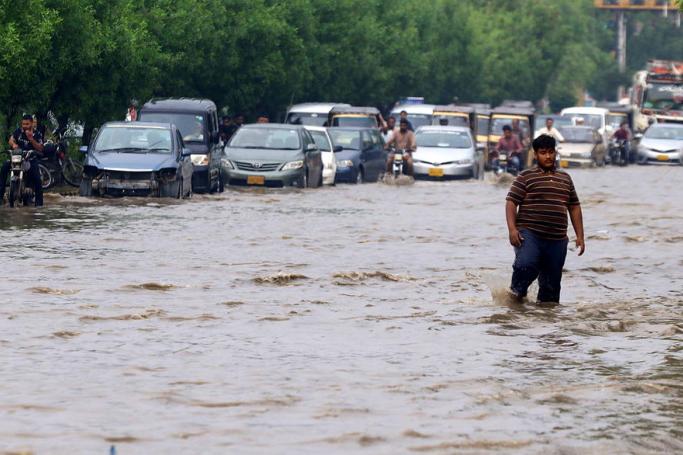 People make their way through a flooded area following heavy rains in Karachi, Sindh province, Pakistan, 13 September 2022. Photo: EPA