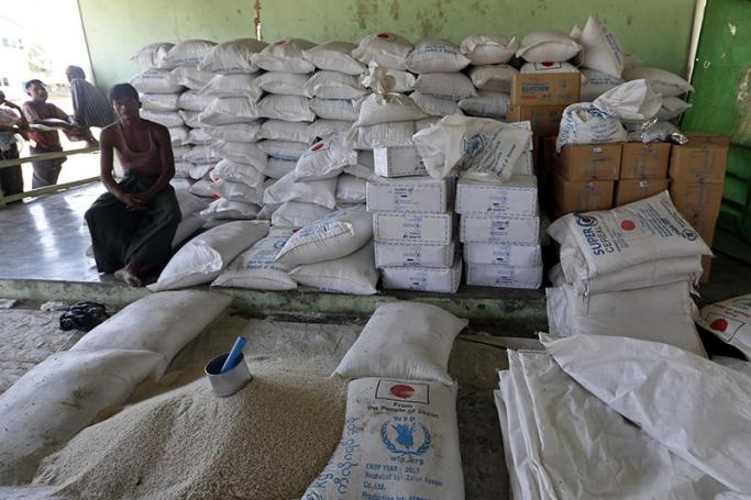 Man sitting near the relief supplies from the World Food Programme (WFP) at the ThetKalPyin camp in Sittwe, Rakhine State, western Myanmar, 01 April 2017. Photo: Nyein Chan Naing/EPA

