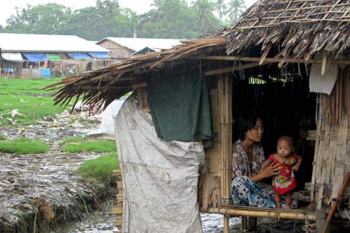 A woman sitting with a baby in her hut near Done Taik Kwin Rakhine IDP camp in Sittwe, Western Myanmar. Photo: EPA
