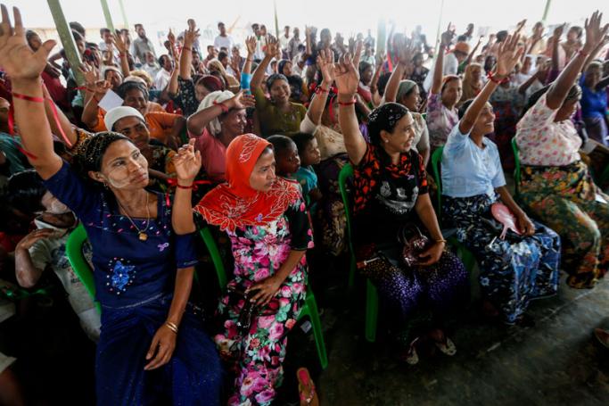 (File) Rohingya women raise their hands as they attend the ceremony to mark the International Women's Day at Thet Kel Pyin Muslim internally displaced person (IDPs) camp near Sittwe of Rakhine State, western Myanmar, 08 March 2017. Photo: Lynn Bo Bo/EPA
