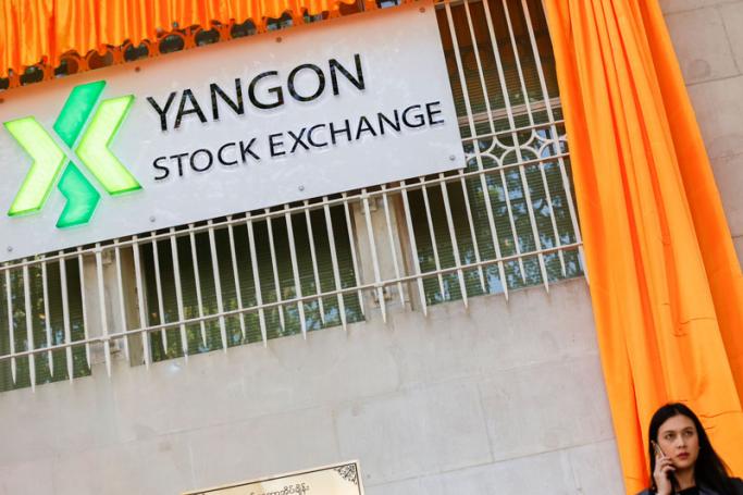 YSX to go online - A woman speaks over over mobile phone in front of Yangon Stock Exchange. Photo: Lynn Bo Bo/EPA
