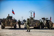 Russian soldiers gather as troops escort a convoy of Syrian civilians leaving the town of Tal Tamr in the northeastern Hasakeh province, to return to to their homes in the northern town of Ain Issa in the countryside of the Raqqa region, via the strategic M4 highway. Photo: AFP