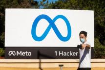 A person takes a selfie in front of a newly unveiled logo for "Meta", the new name for Facebook's parent company, outside Facebook headquarters in Menlo Park on October 28, 2021. Photo: AFP