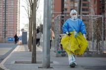 A volunteer health worker walks on the street in Beijing, December 7, 2022. Photo: EPA