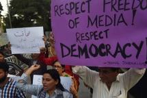 File Photo: Pakistani journalists and civil society activists hold placards against the attack on a senior journalist of a local newspaper in Karachi. / Photo: AFP