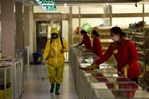 FILES) In this file photo taken on March 18, 2022 employees spray disinfectant and wipe surfaces as part of preventative measures against the Covid-19 coronavirus at the Pyongyang Children's Department Store in Pyongyan. Photo: AFP
