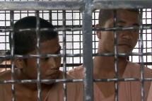 The Myanmar migrant workers who are accused of the killing of two British tourists, Wai Phyo (L) and Zaw Lin Oo (R), sit behind the bars of a prison vehicle as they arrive for trial at court on Samui island, Surat Thani province, Thailand, December 8, 2014.  Photo: Sitthipong Charoenjai/EPA
