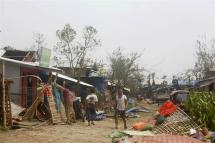 People walk among the debris after cyclone Mocha made landfall in Sittwe, Rakhine State, Myanmar, 15 May 2023. Photo: EPA