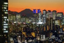 apan's highest peak of Mount Fuji, 3,776m, is seen through Shinjuku skyscrapers in Tokyo, Japan. Photo: EPA