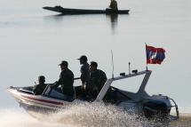 (FILES) Laos armed army soldiers patrol in a speedboat past a small fishing boat bearing the Laos flag on the less than one kilometer wide Mekong River, the natural border between Thailand and Laos where the Laos capital Vientiane is situated, Sunday 28 November 2004. Photo: EPA
