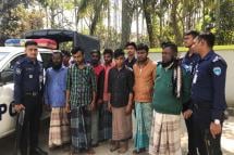 Bangladesh policemen stand next suspected human traffickers following their arrest, in Teknaf on February 13, 2020. Photo: AFP