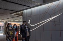 People walk past a Nike store in a shopping area of Sanlitun in Beijing, China. Photo: EPA