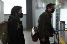 Wall Street Journal reporters Josh Chin (right) and Philip Wen walk through Beijing Capital Airport as they are expelled in February 2020 over a controversial headline in an op-ed in the newspaper (AFP PHOTO/File / GREG BAKER)