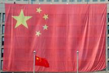 A worker hangs a large Chinese national flag covering a local government building to celebrate the upcoming National Day in downtown Qingdao city, eastern China's Shandong province, September 30, 2011. Photo: Wun Hong/EPA
