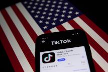 (File) A generic illustration shows the icon of Chinese internet media app TikTok on a phone, and the US flag on a laptop screen, in Beijing, China, 21 September 2020. Photo: EPA