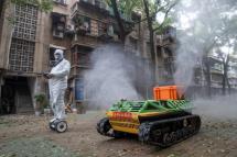 A volunteer operates a remote controlled disinfection robot to disinfect a residental area amid the COVID-19 coronavirus outbreak in Wuhan in China's central Hubei province on March 16, 2020. Photo: AFP