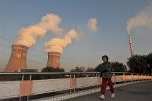 (File) Local residents pass by a coal powered thermal power plant cooling tower in Shenyang, northeast China 30 October 2008. Photo: EPA