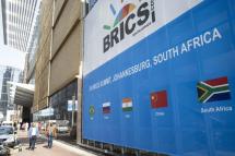 People walk past a banner as final preparations are underway for the 15th BRICS Summit at the Sandton Convention Centre, Johannesburg, South Africa, 20 August 2023. Photo: EPA