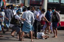 A resident falls to the ground as pro-military supporters attack residents with sling shots and projectiles near the central railway station in Yangon, Myanmar, 25 February 2021. Photo: EPA