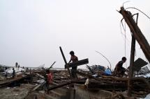 Local residents clean debris of their destroyed houses at the Khaung Dote Khar Rohingya refugee camp in Sittwe, in Myanmar's Rakhine state, on May 15, 2023, after cyclone Mocha made a landfall. Photo: AFP