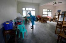 A Red Cross volunteer sprays disinfectant at a quarantine facility center in Yangon, Myanmar, 15 October 2020. Photo: Nyein Chan Naing/EPA