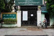 (File) A man pushes his bicycle as he comes out from a closed entrance of a school at downtown area in Yangon, Myanmar, 27 August 2020. Photo: Lynn Bo Bo/EPA