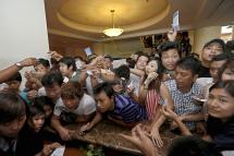 Crowds of young people crush the counter as they try to buy the new mobile handset in Yangon. Photo: Nyein Chan Naing/EPA
