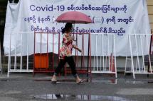Myanmar woman walks pass in front of the COVID-19 test center at downtown area of Yangon, Myanmar. Photo: EPA