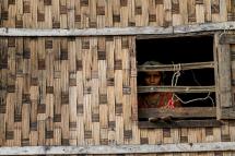 A girl looks out from a destroyed house at Ohn Taw Chay refugee camp in Sittwe on May 16, 2023, in the aftermath of Cyclone Mocha's landfall. Photo: AFP