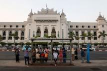This photo taken on March 17, 2020 shows people waiting at a bus stop across the Yangon City Hall in Yangon.  Photo: AFP