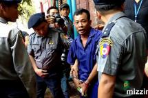 Detained prosecution witness police captain Moe Yan Naing (C) is escorted by police talks to media as he leaves the court after a hearing of Reuters' journalists trial in Yangon on 09 May 2018. Photo: Mizzima
