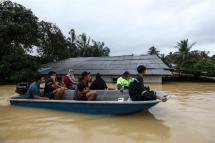 People use a boat through a flooded area in Kuala Terengganu, Malaysia, 21 December 2022. Photo: EPA