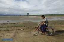 A man rides a bicycle next to a flooded paddy field in Kalay Township, Sagaing Region on September 3, 2015. Photo: Hong Sar/Mizzima
