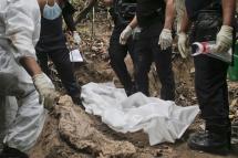 Members of Royal Malaysia Police forensic team exhume human remains from a grave found at Wang Burma hills at Wang Kelian, Perlis, Malaysia, 26 May 2015. Photo: EPA