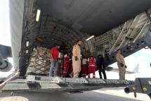 Volunteers from Qatar and Egypt's Red Crescent unload aid destined for the Gaza Strip at Egypt's El Arish airport / Photo: AFP