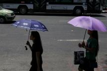 (File) Myanmar girls use umbrellas to protect themselves from the sun at downtown area in Yangon, Myanmar. Photo: EPA