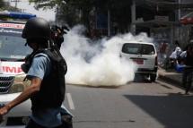 A journalist films as riot police fire tear gas at demonstrators during a protest against the military coup, near Myaynigone in Yangon, Myanmar, 27 February 2021. Photo: EPA