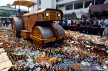 Indonesian officers destroy alcohol in Jakarta, Indonesia, on Thursday 21 September 2006. East Jakarta Police and the municipal administration bulldozed Thursday over 30.907 bottles of alcoholic drinks and millions of bootleg discs. Photo: Bagus Indahono/EPA
