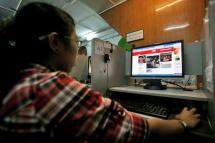 A girl watches the website of CNN at a internet cafe in Yangon, Myanmar. Photo: EPA
