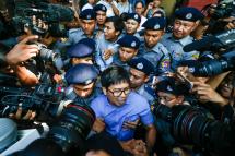 Reuters' journalists Wa Lone (C, front) and Kyaw Soe Oo (C, back) are escorted by police as they leave the court after their first trial in Yangon, Myanmar, 10 January 2018. Photo: Lynn Bo Bo/EPA