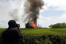 Journalist take photos of a burning house at the Gawdu Thara village in Maungdaw township, Rakhine State, western Myanmar, 07 September 2017. Photo: Nyein Chan Naing/EPA

