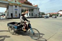 A Myanmar woman drives rides a tricycle as she crosses into China at the China-Myanmar, Kyegaung border gate, in Ruili, Yunnan province, China, September 17, 2012. Photo: Nyein Chan Naing/EPA
