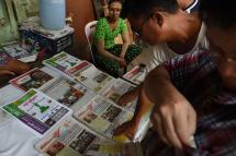 Local residents buy newspapers in Yangon. Photo: AFP