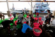 Migrant fishermen from Myanmar on Thai fishing boats sort fish by size at the port in Samut Sakhon province, Thailand, 11 March 2016. Photo: Diego Azubel/EPA
