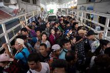 This photo taken on July 7, 2017 shows migrant workers passing the Thai-Myanmar border in an official service truck as they left Thailand from Mae Sot, Tak province in northern Thailand. Photo: Ye Aung Thu/AFP
