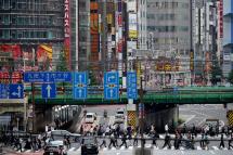 Pedestrians cross a large street at Shinjuku business and entertainment district in Tokyo, Japan, 18 May 2021. Photo: EPA