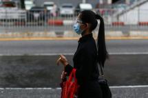 A girl wearing protective face mask and a shield as she waits for taxi at downtown area despite the stay-at-home order to prevent the spread of COVID-19, Yangon, Myanmar, 21 September 2020. Photo: EPA