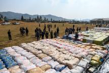 (File) Foreign military attaches check drugs in a football ground where seized drugs, vehicles, laboratory accessories and precursor chemicals are being displayed to be witnessed by invited military attaches and journalists in Kawnghka at Shan State on March 6, 2020. Photo: Ye Aung Thu/AFP